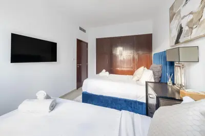 a hotel room with two beds and a flat screen tv at Burj and Fountain view 3BR plus maids room in Dubai