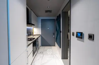 a kitchen with white walls and a hallway at Canal View Studio MAG 318 in Dubai
