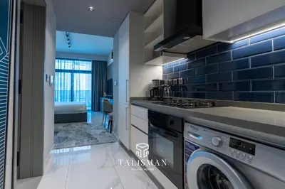 a kitchen with a washer and a washing machine at Canal View Studio MAG 318 in Dubai