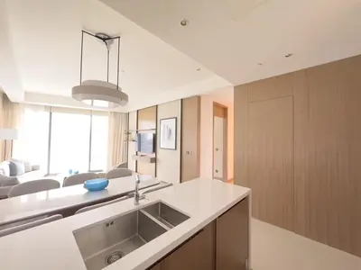 a kitchen with a sink and a living room at ADDRESS Residences Opera 2BR Tower 1 - EPIC 30th floor Burj Khalifa view byBLCK with DXB AIRPORT VIP Shuttle option in Dubai