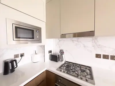 a kitchen with a stove and a microwave at ADDRESS Residences Opera 2BR Tower 1 - EPIC 30th floor Burj Khalifa view byBLCK with DXB AIRPORT VIP Shuttle option in Dubai