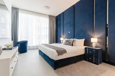 a bedroom with a large bed and a blue wall at 3BR Apartment in the heart of Dubai Marina in Dubai