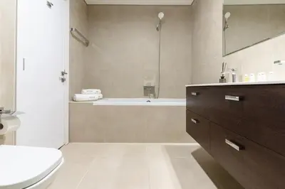 a bathroom with a tub and a toilet and a sink at 3BR Apartment in the heart of Dubai Marina in Dubai