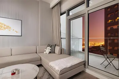 a living room with a couch and a large window at Modern 1BR in Avanti with Pool & Gym in Dubai