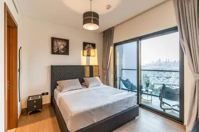 a bedroom with a bed and a large window at Sobha Waves Grande Big 1BR apt Burj Khalifa views! in Dubai