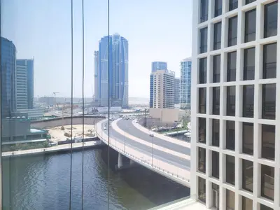 a bridge over a river in a city with buildings at Damac Voleo - Blue Ocean Holiday Homes in Dubai
