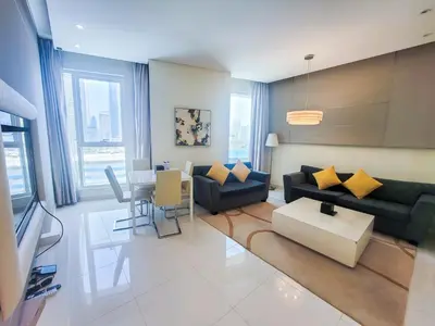 a living room with a couch and a table at Damac Voleo - Blue Ocean Holiday Homes in Dubai
