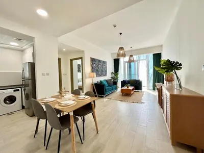 a kitchen and living room with a table and chairs at Homes2Retreat - Luxury Finishes with Full Skyline View in Dubai