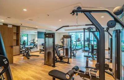 a gym with several treadmills and machines in it at Burj Views Elegance from 3 Bedroom Apartment 214-A1-3 in Dubai