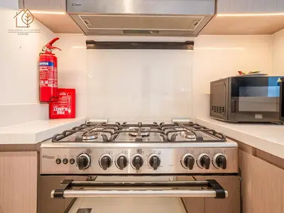 a kitchen with a stove and a microwave at Burj Views Elegance from 3 Bedroom Apartment 214-A1-3 in Dubai