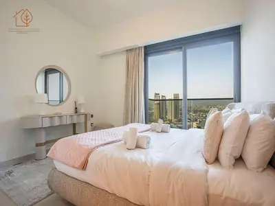 a bedroom with a large bed with a large window at Burj Views Elegance from 3 Bedroom Apartment 214-A1-3 in Dubai