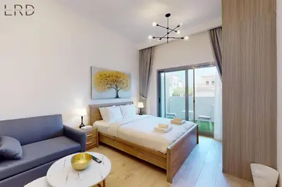 a bedroom with a bed and a blue couch at Brand New and Modern Studio Apartment in Dubai