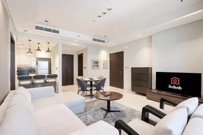 a living room with white furniture and a tv at Centrally Located 1BR in Business Bay Near Canal and Downtown in Dubai