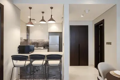 a kitchen with a bar with stools and a table at Centrally Located 1BR in Business Bay Near Canal and Downtown in Dubai