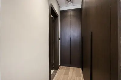 a hallway with wooden cabinets and a door at Centrally Located 1BR in Business Bay Near Canal and Downtown in Dubai