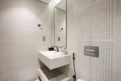 a white bathroom with a sink and a mirror at Centrally Located 1BR in Business Bay Near Canal and Downtown in Dubai