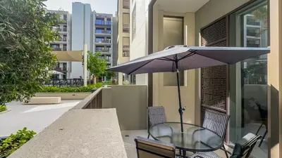 a table with an umbrella and a table and chairs at Resort-Style 1BR in Dubai Creek Harbour -1AB01 in Dubai