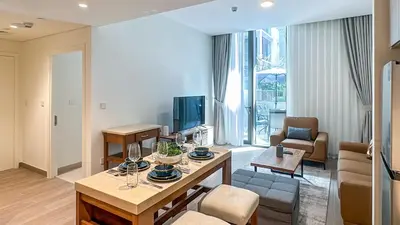 a living room with a table and a couch at Resort-Style 1BR in Dubai Creek Harbour -1AB01 in Dubai