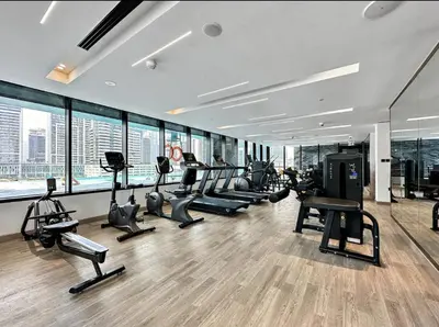 a gym with a bunch of treadms and elliptical machines at Studio With Jaw-Dropping Canal And Burj Views in Dubai