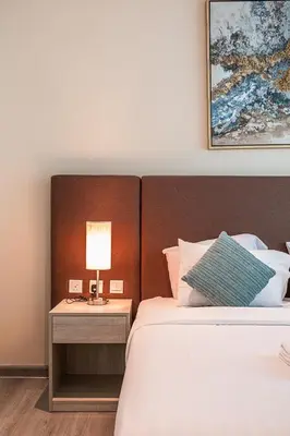 a bedroom with a bed and a lamp on a table at Bright & Elegant Saven The Palm 1bhk Apartment in Dubai