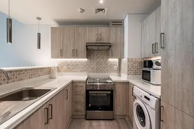 a kitchen with a stove and a dishwasher at Bright & Elegant Saven The Palm 1bhk Apartment in Dubai