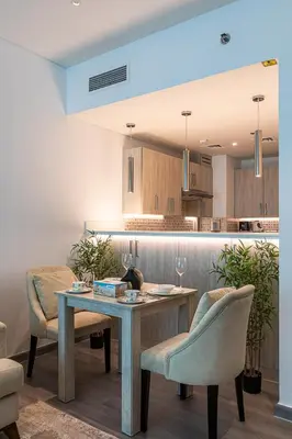 a kitchen with a table with a cat sitting on it at Bright & Elegant Saven The Palm 1bhk Apartment in Dubai