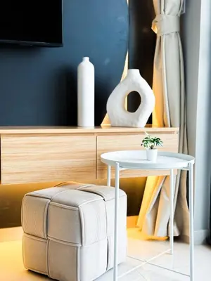 a table and a stool next to a table with at CasaHue - Canal x Burj View - 4Guest - Award Winning in Dubai