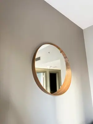 a round mirror on a white wall in a room at CasaHue - Canal x Burj View - 4Guest - Award Winning in Dubai