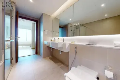 a bathroom with two sinks and a large mirror at Elegant 2BR with Maids and Stunning Canal Views in Dubai
