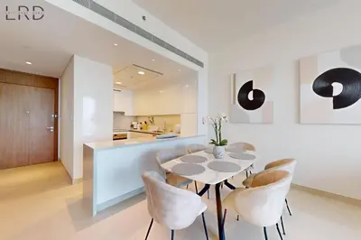 a kitchen and dining room with a table and chairs at Elegant 2BR with Maids and Stunning Canal Views in Dubai