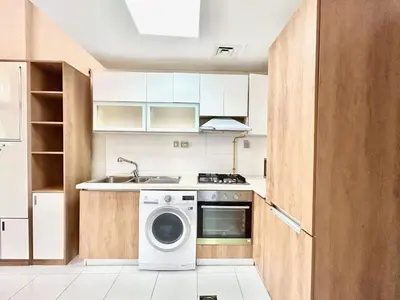 a kitchen with a washing machine and a sink at Homes2Retreat - Glamz Haven Stylish Studio with Balcony in Dubai