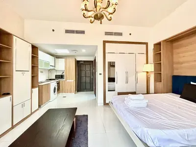 a large bedroom with a bed and a chandelier at Homes2Retreat - Glamz Haven Stylish Studio with Balcony in Dubai