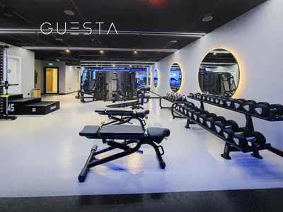 a gym with a row of exercise bikes and weights at Hamilton House, Jumeirah Village Circle in Dubai
