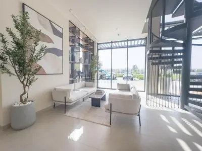 a living room with white furniture and a potted plant at New Studio Close to Town Square Park, Short Drive to Al Qudra Lake, Liva Apartments by Deluxe Holiday Homes in Dubai