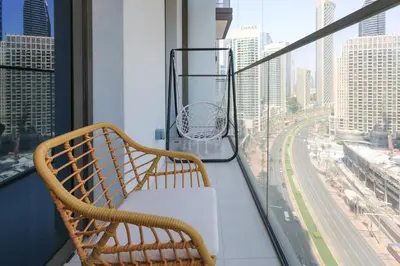 a bench on a balcony with a view of a city at High-Rise & Boulevard View - 5-min to Burj & Mall in Dubai