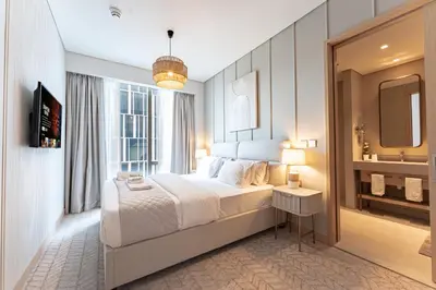 a bedroom with a large bed and a bathroom at Luxurious 1BR Pool with Burj Khalifa View Dubai Mall in Dubai