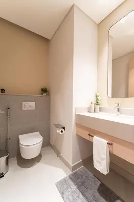 a bathroom with a toilet and a sink and a mirror at Luxurious 1BR Pool with Burj Khalifa View Dubai Mall in Dubai