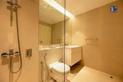a bathroom with a toilet and a glass shower at Luxury Escapes - Breathtaking 1BR with Sea View Port Lamer in Dubai