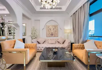 a living room with orange furniture and a chandelier at Upgraded 2bdr with acess to Dubai Mall in Dubai