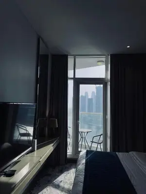 a bedroom with a bed and a balcony with a table at Damac Prive in Dubai
