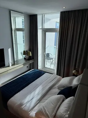 a bedroom with a large bed and a large window at Damac Prive in Dubai