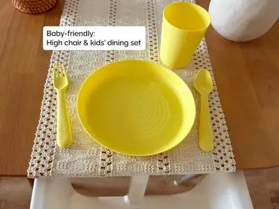 a yellow bowl on a table with utensils at Stylish Lakefront Studio with King Bed and Balcony in Dubai