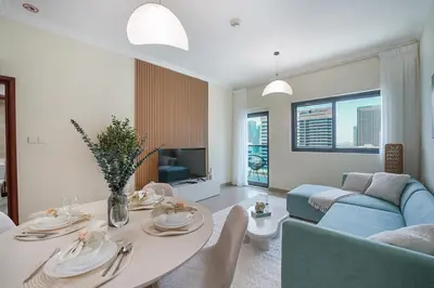 a living room with a table and a blue couch at EasyGo-Marina Living with View and Amenities in Dubai