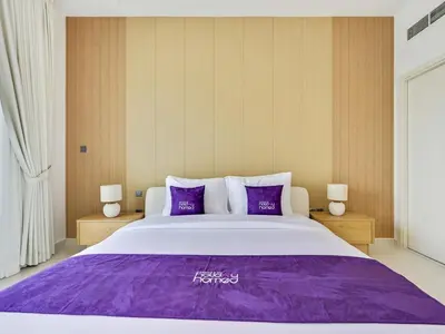 a bedroom with a large bed with purple sheets at 4BR Luxurious Villa DAMAC Hills 2 in Dubai