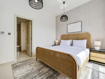 a bedroom with a large bed with white sheets at 4BR Luxurious Villa DAMAC Hills 2 in Dubai