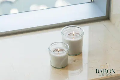 two candles sitting on the floor in front of a window at The Classy in Dubai