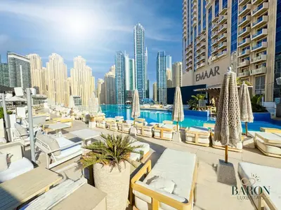 a resort with a pool and chairs and buildings at The Classy in Dubai