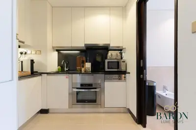 a kitchen with stainless steel appliances and white cabinets at The Classy in Dubai