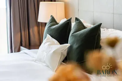 a bed with green and white pillows on it at The Classy in Dubai