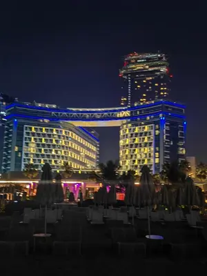 a view of a city at night with buildings at Seven Palm Jumeirah Studio in Dubai